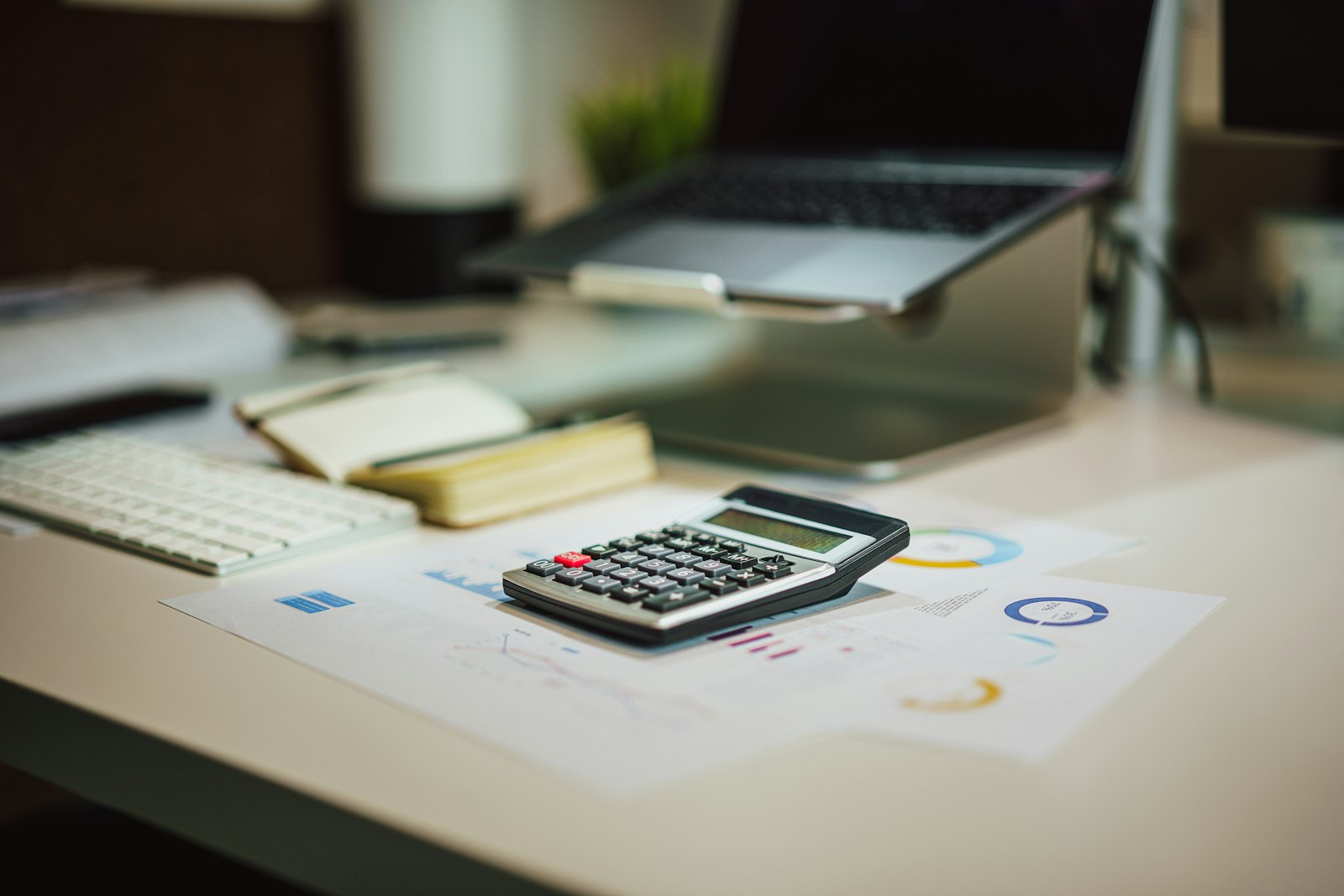 Calculator, planner and laptop on a bright desk